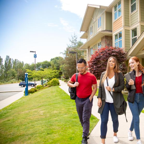 Three students walk together outside of VIU Residences