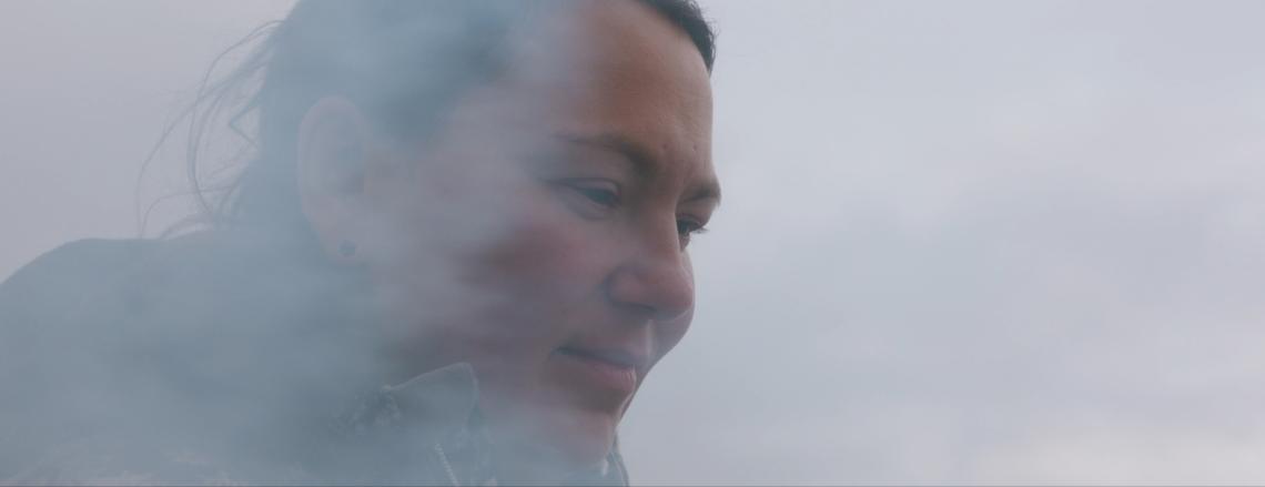 Tanya Taqaq's face surrounded by smoke or fog