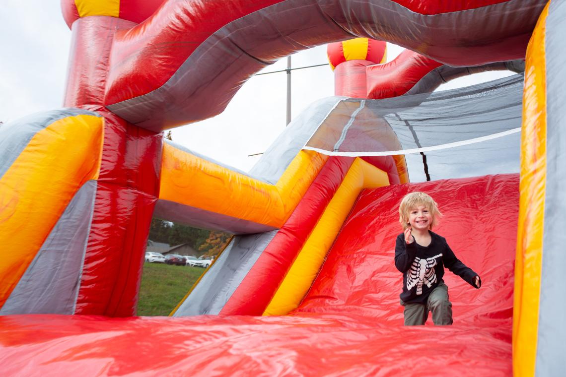 A boy runs down an inflatable slide