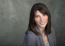 Dr. Lindsay McCunn smiles at the viewer while wearing a grey blazer and shirt.