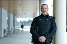 Drew Milne portrait next to VIU's Centre for Health and Science