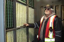 A man in a safety vest standing by an air filtration system