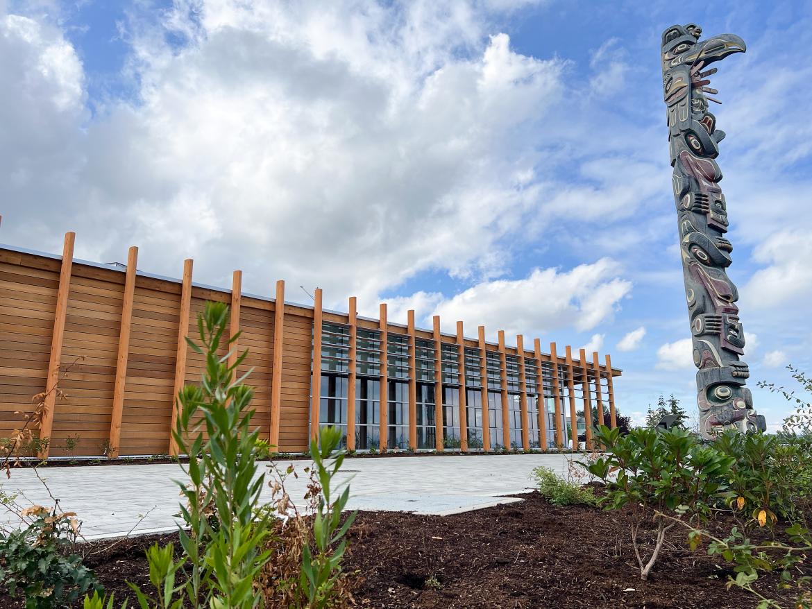 Photo of exterior of building with totem in foreground