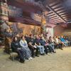 A group of students sits in a longhouse